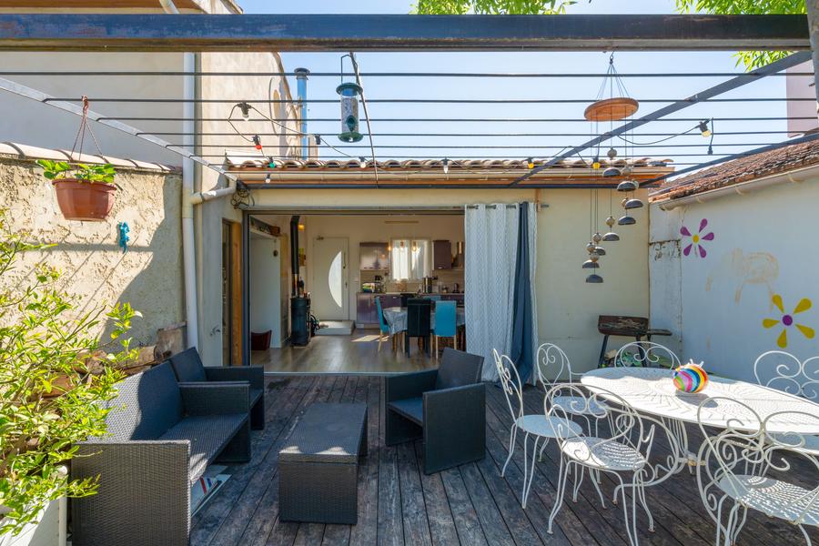 An outdoor terrace with wooden floors, furnished with