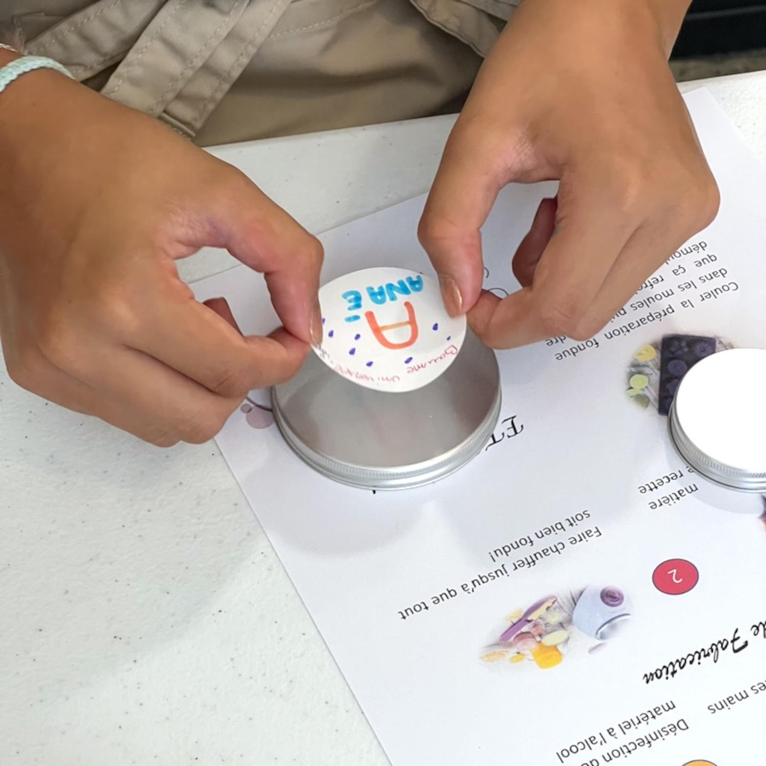 Two hands placing a colored label with the letter 
