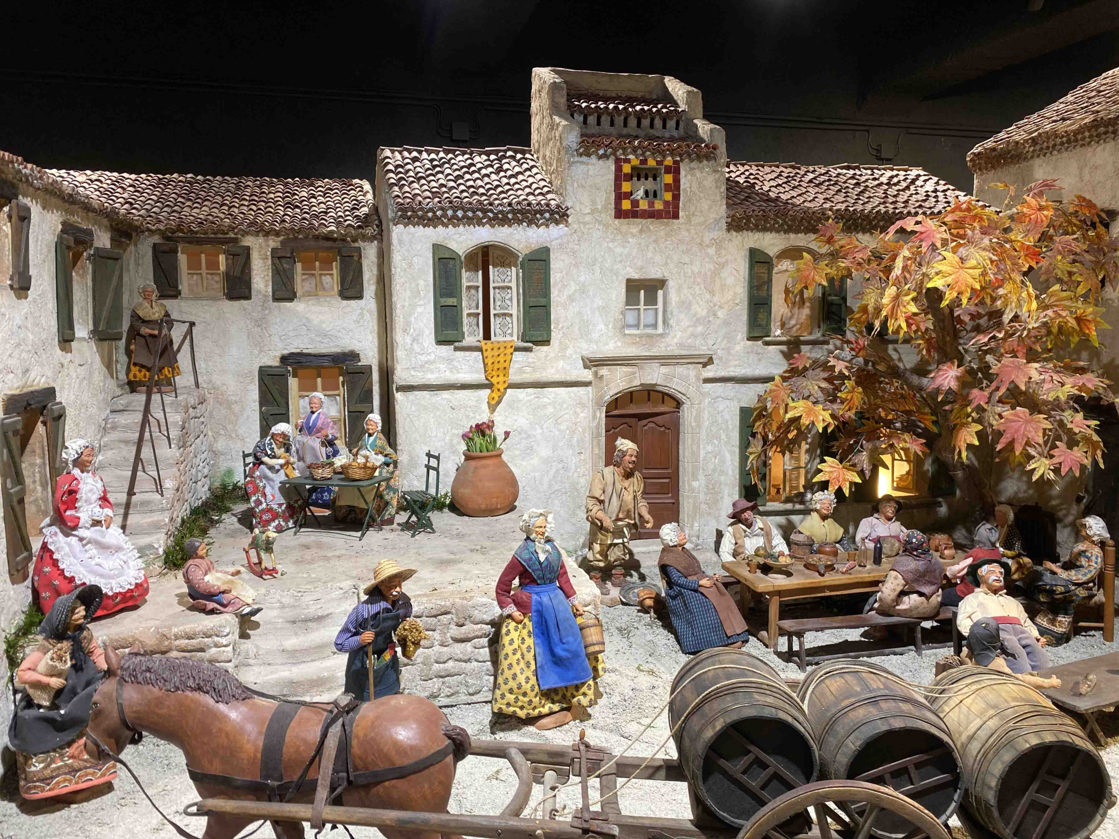A model of a Provençal village with figures representing scenes of daily life, such as meals and a workhorse.