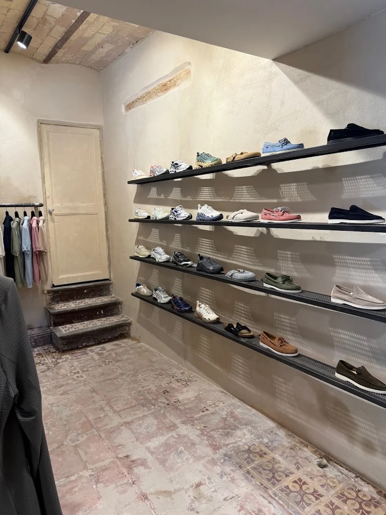 Space tiled floor made of very worn cement tiles, sneakers and shoes 