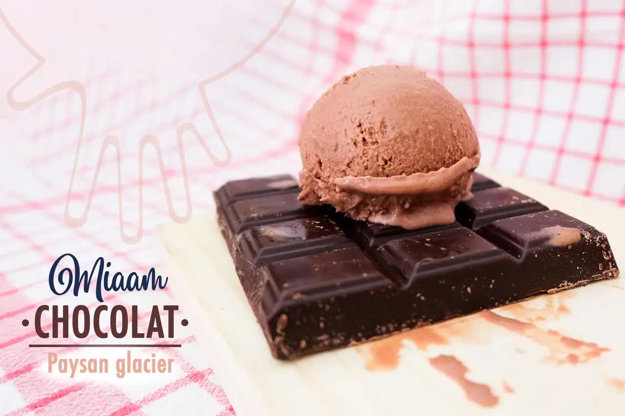 A scoop of chocolate ice cream placed on a dark chocolate bar, representing the delicacy and authenticity of Miaam homemade ice cream.