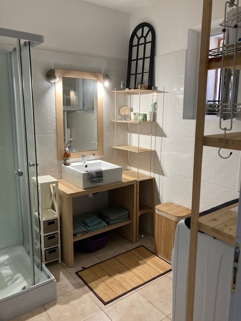Bathroom with a white and wooden shower.