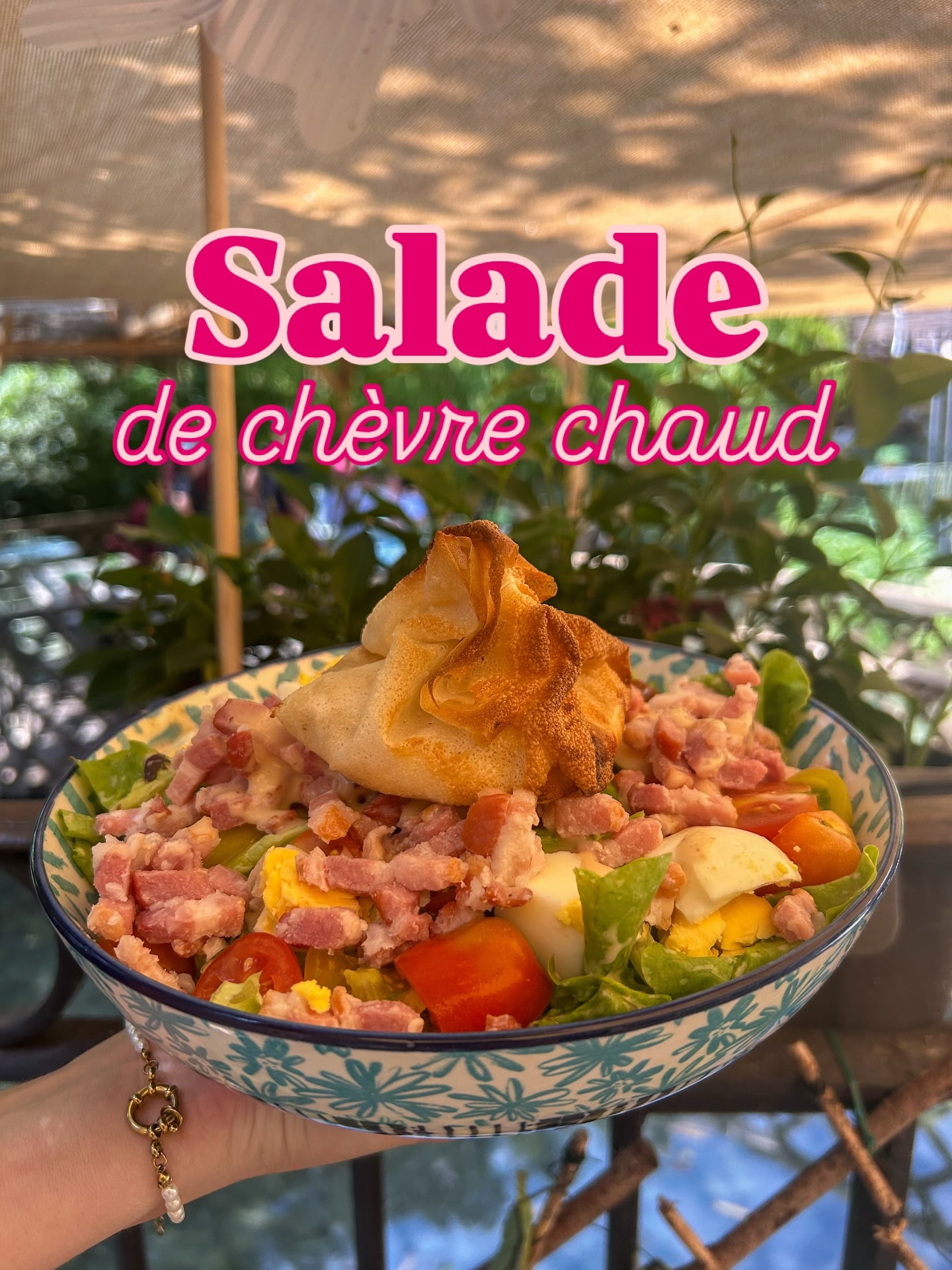 Hot goat cheese salad in a porcelain dish with vegetation in the background