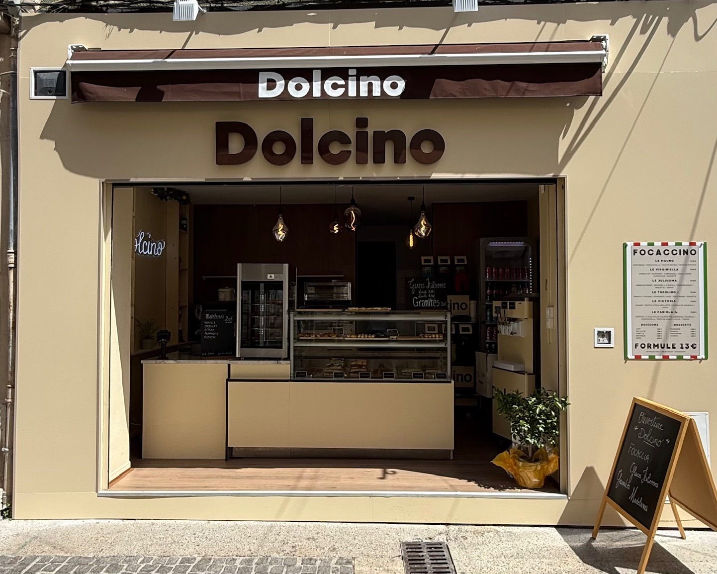Facade of Dolcino in the city center, Italian sandwich shop offering focaccias, desserts and gourmet specialties in a warm atmosphere.