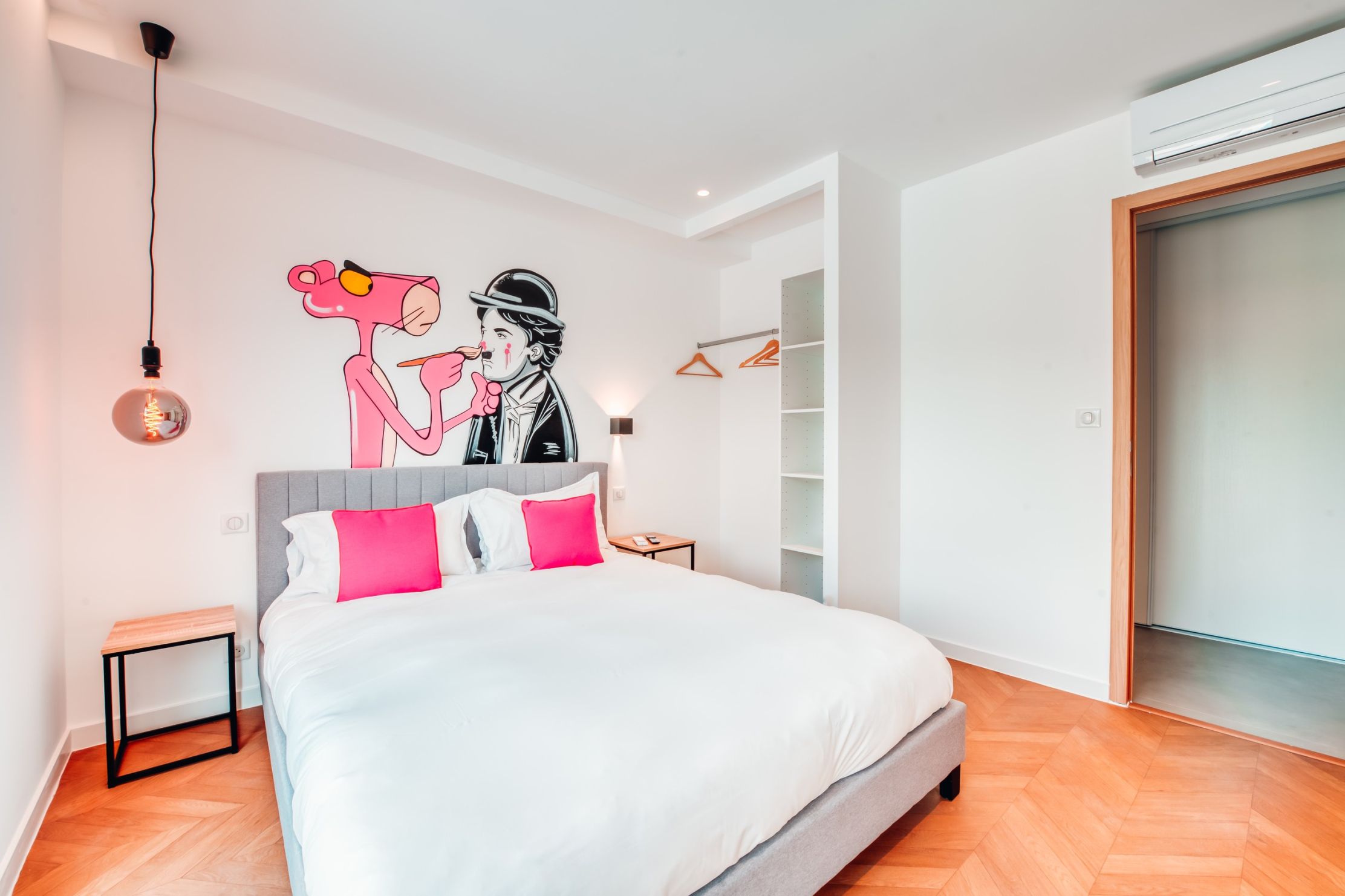 Air-conditioned double room with a pop and quirky atmosphere, decorated with a large wall fresco featuring the Pink Panther and Charlie Chaplin. A bright and original space.